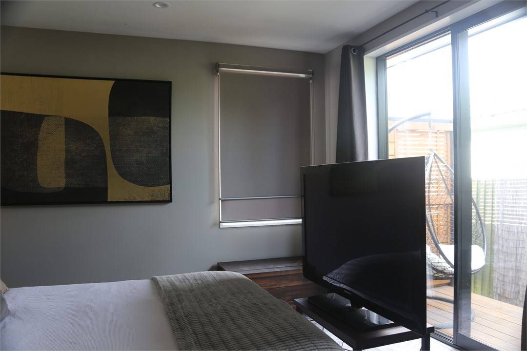 Inside, a 50-inch TV sits at the foot of the bed. 