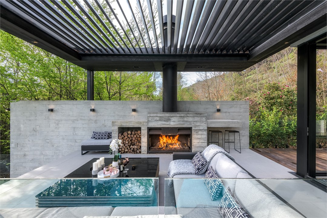 Seating areas outside by the pool and fireplace