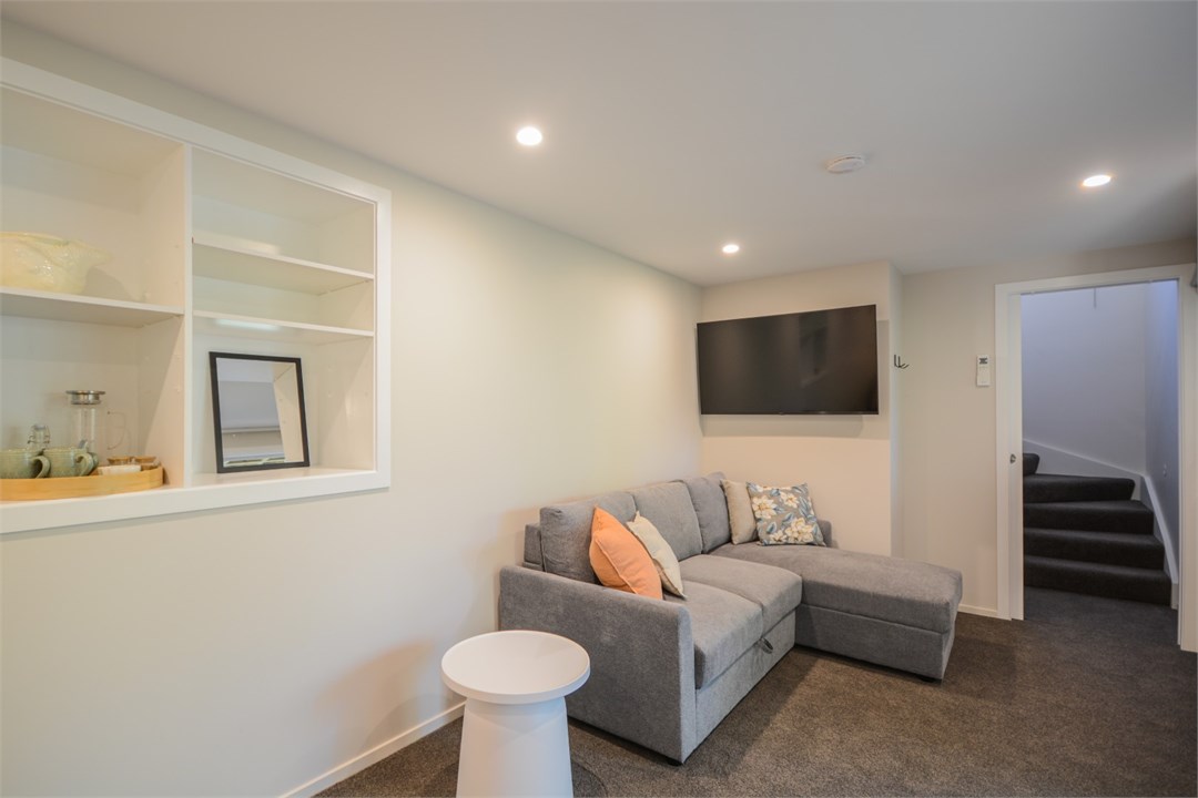 Bedroom 2 has a Queen bed, TV and a seating area