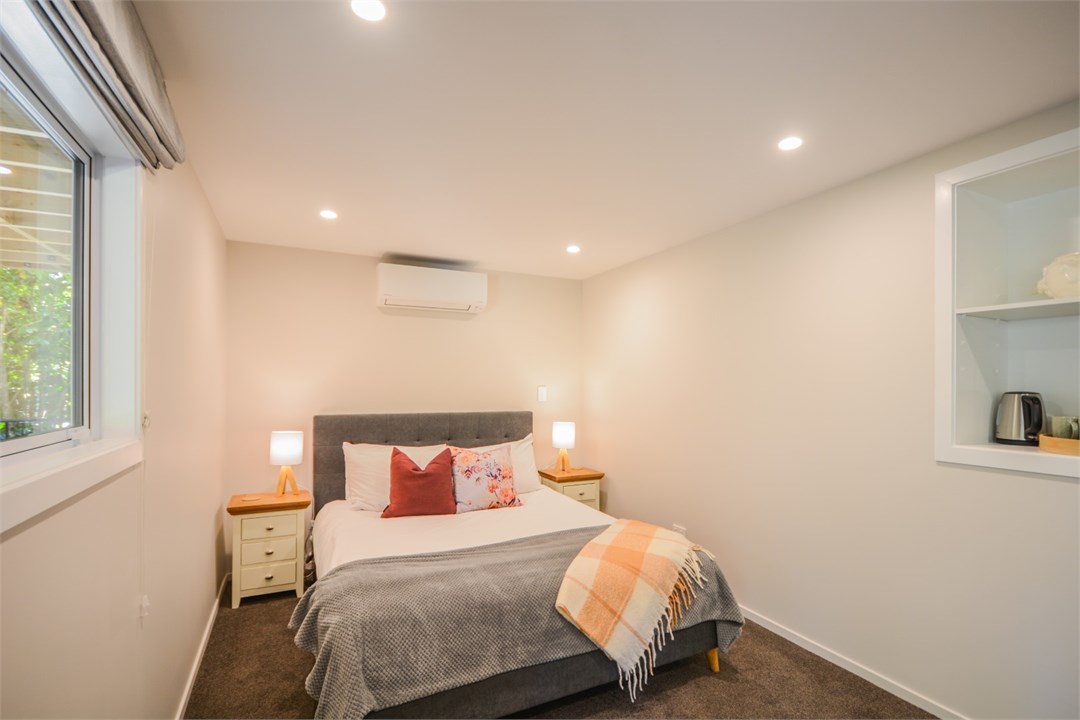 Bedroom 2 has a Queen bed, TV and a seating area