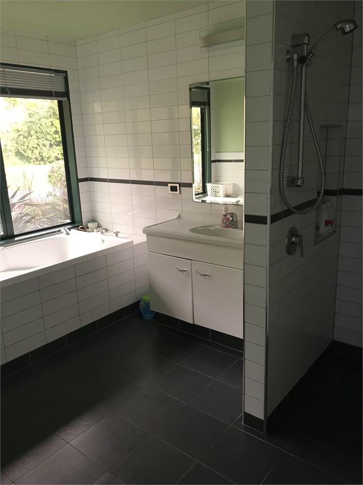 Large bathroom with a walk in shower and spa bath.