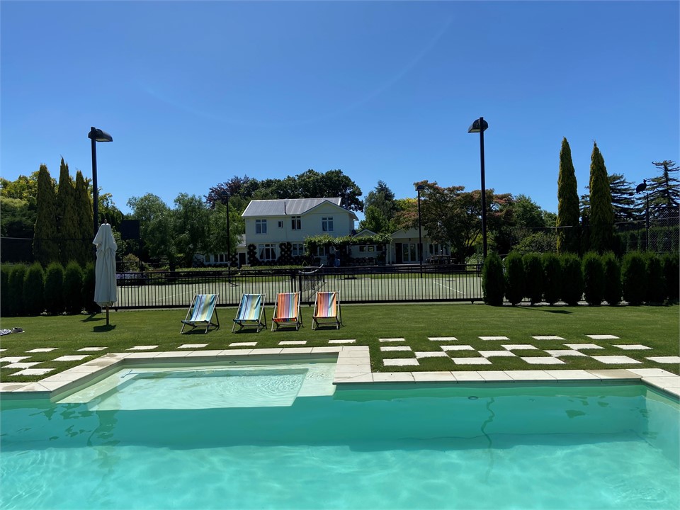 View of pool looking back over tennis court  towar