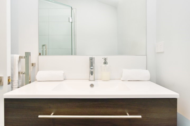 Clean bathroom with toilet, vanity mirror and show