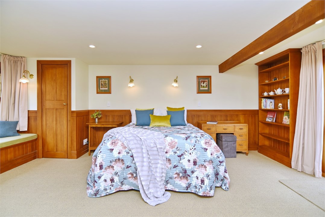 The bedroom has a Queen bed and seating areas