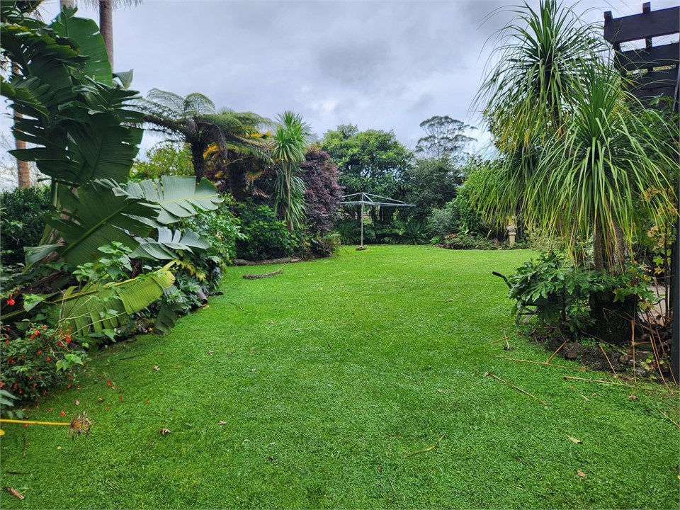 Backyard beside closed in deck.  Clothes line.