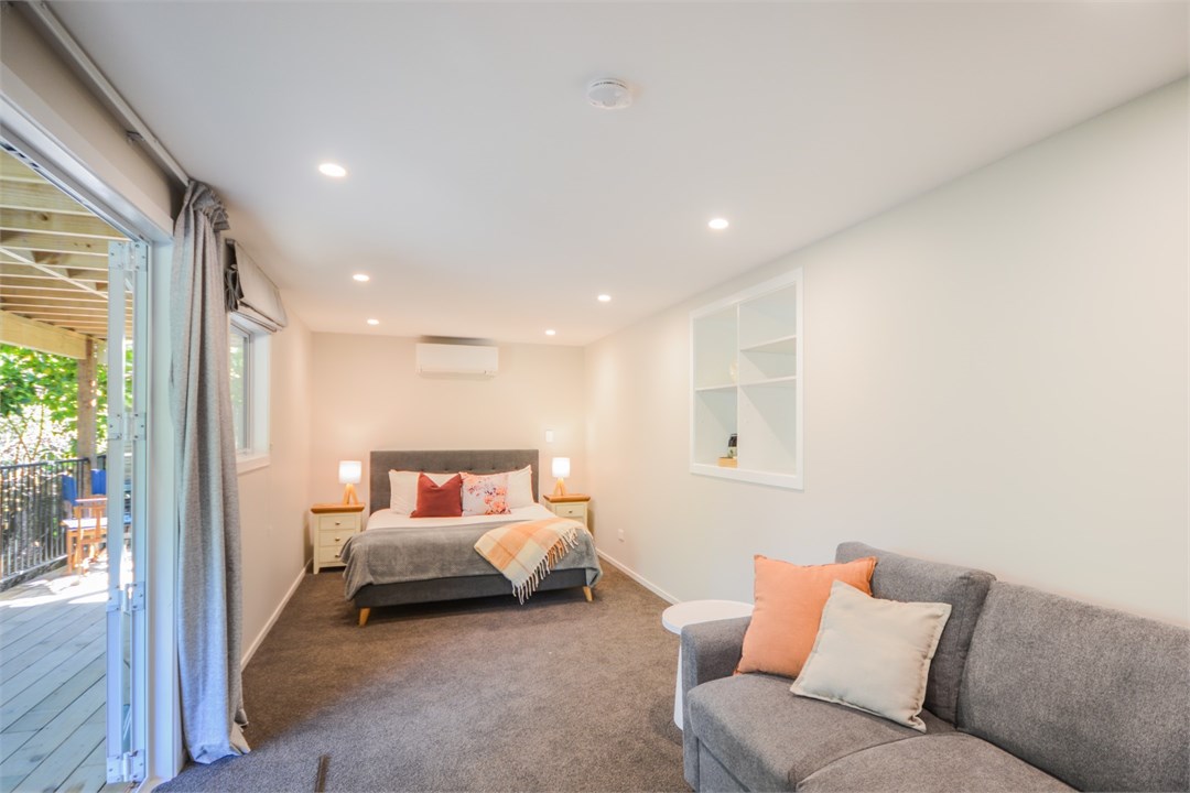 Bedroom 2 has a Queen bed, TV and a seating area