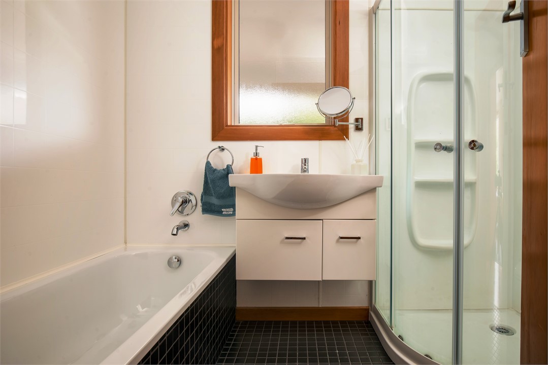 The modern bathroom has a bath and shower