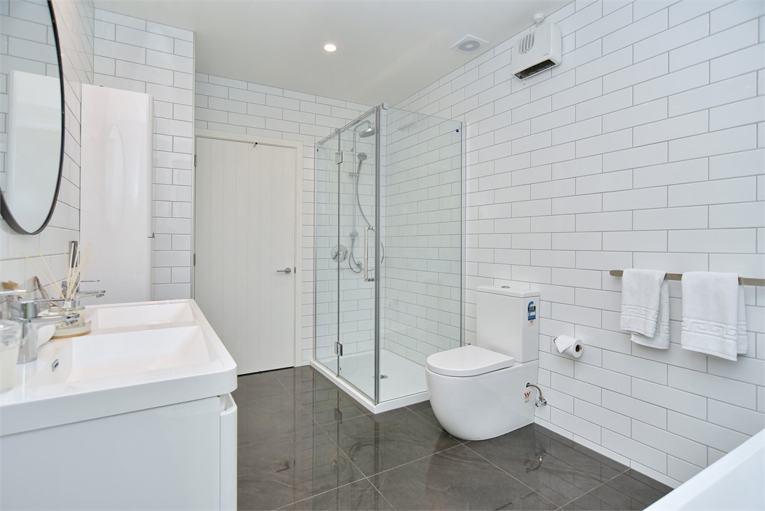 The master bathroom is clean, modern, and white.