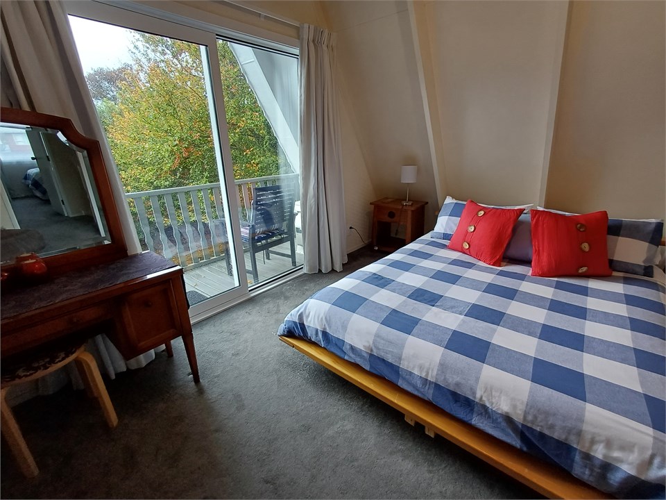 Upstairs bedroom 1 with queen bed. Opens onto priv