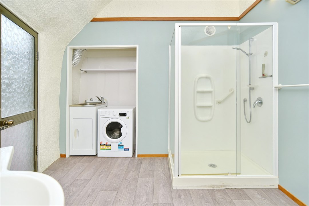 Bathroom has a shower and laundry area