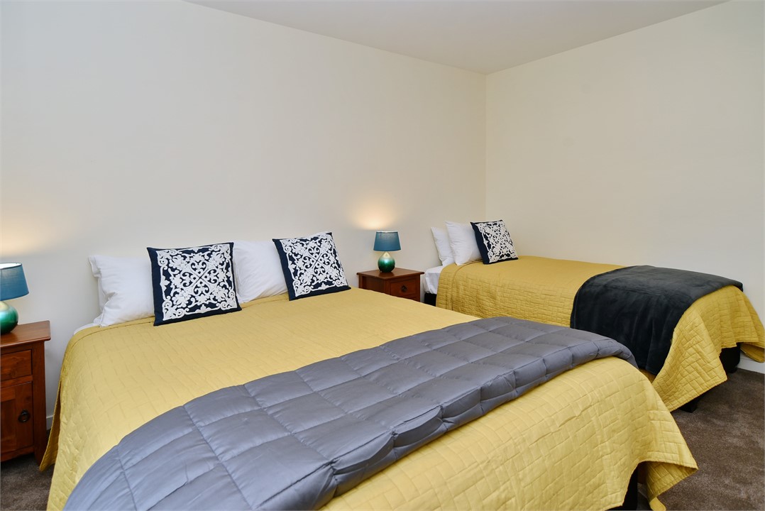 Bedroom 2 includes a queen bed and a single bed